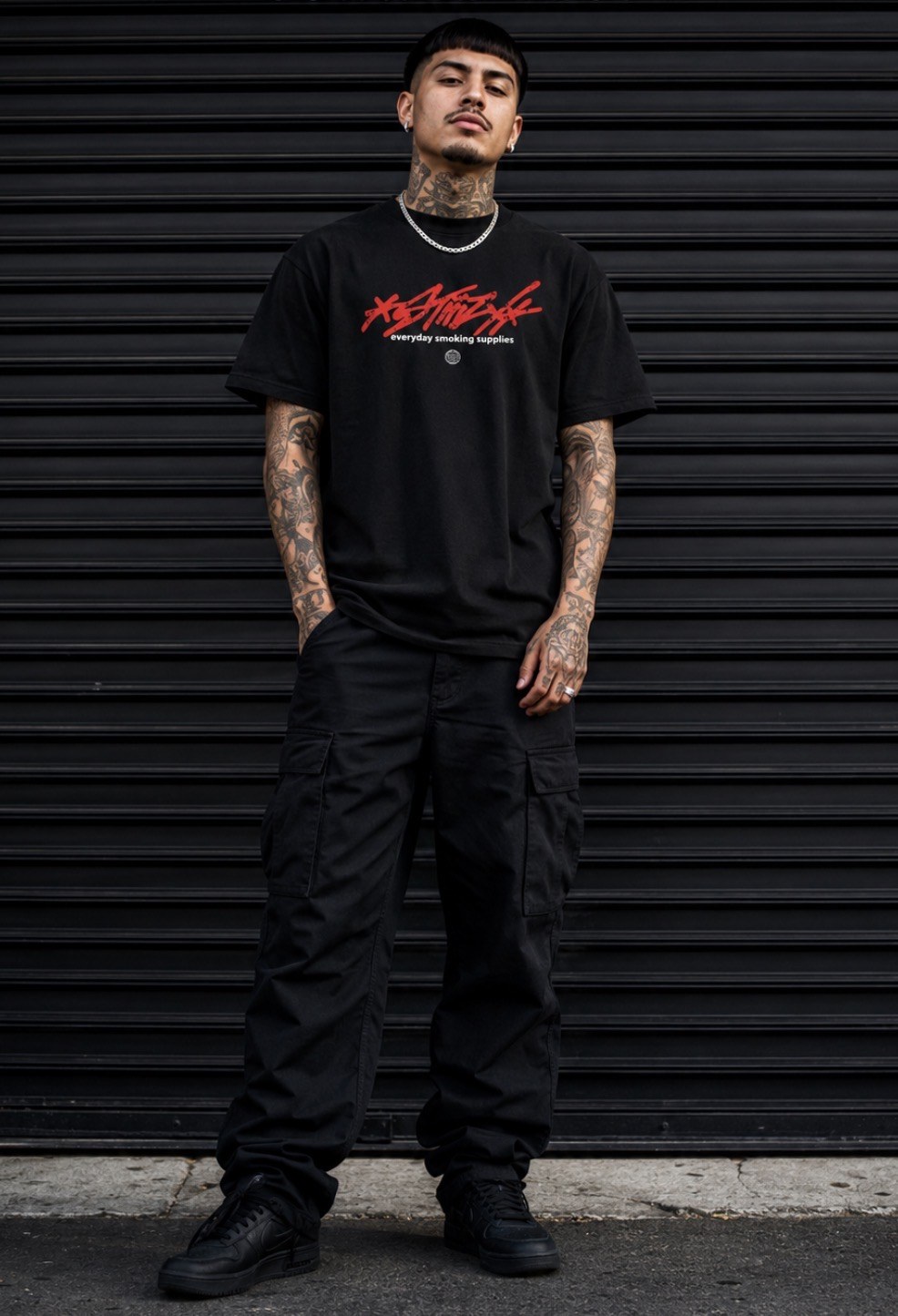 STIIIZY black outfit portrait in front of a shutter